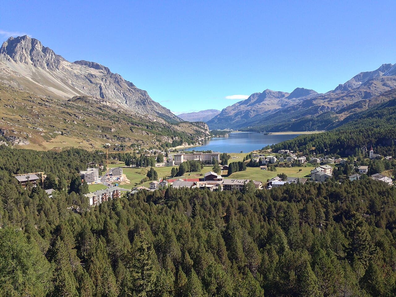 Maloja e lago di Sils visti dalla Torre Belvedere, con il Maloja Palace al centro e le montagne sullo sfondo